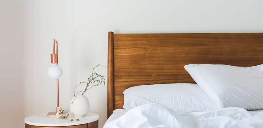 Inside image of a house bed with a table lamp